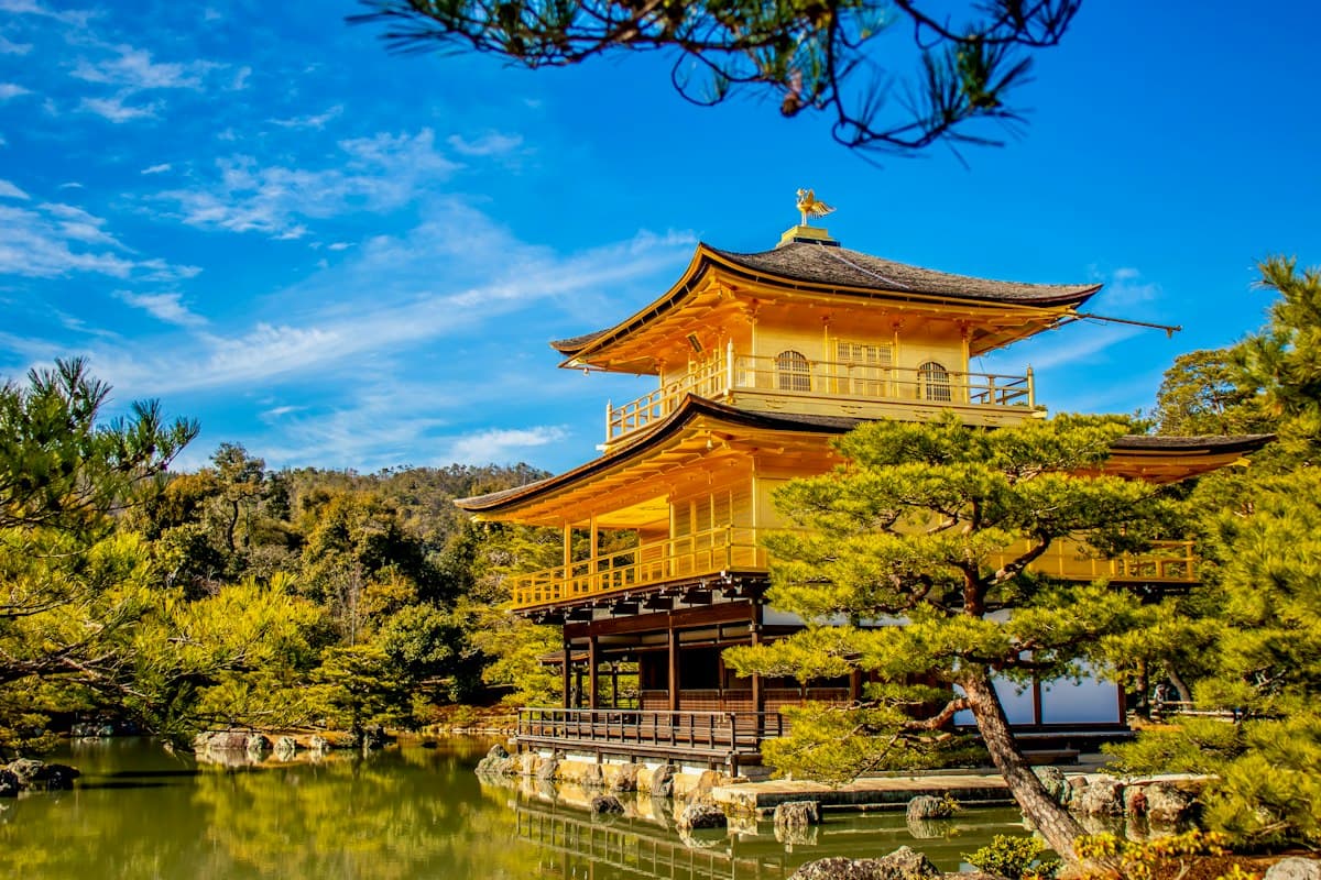 Chùa Vàng Kinkaku-ji soi bóng xuống hồ giữa hàng cây xanh ở Kyoto